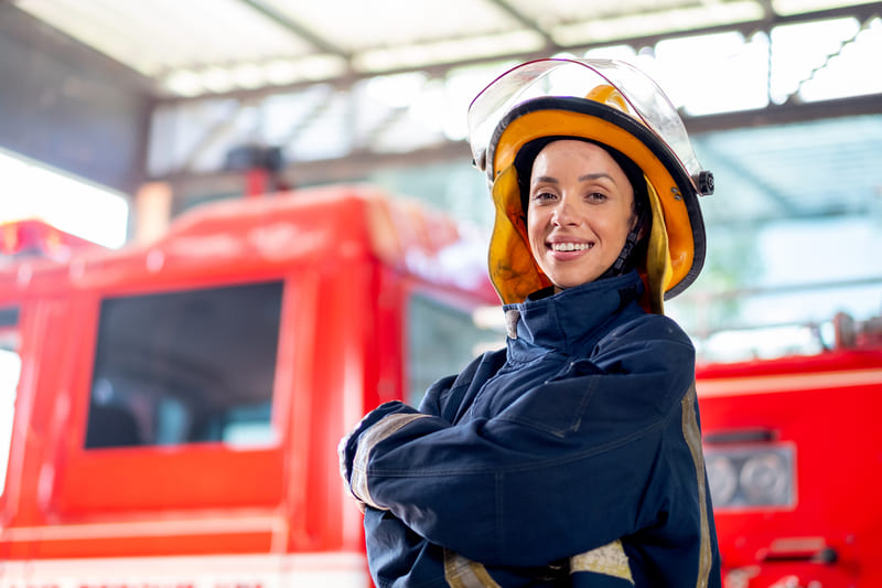 fire-fighting-training-side-view-of-fireman-or-firefighter-woman-with-protective-clothes-stand-with-confidence-action-and-smile-in-fr