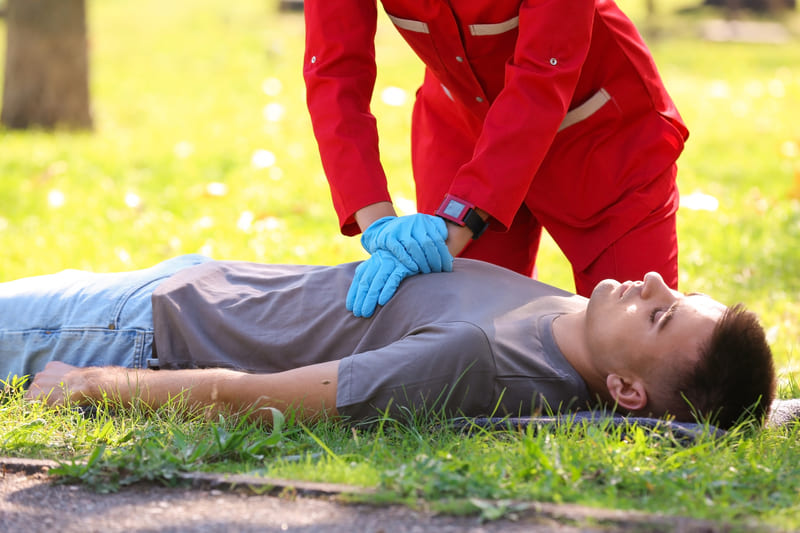 first-aid-training-woman-in-uniform-performing-cpr-on-unconscious-man-outdoors